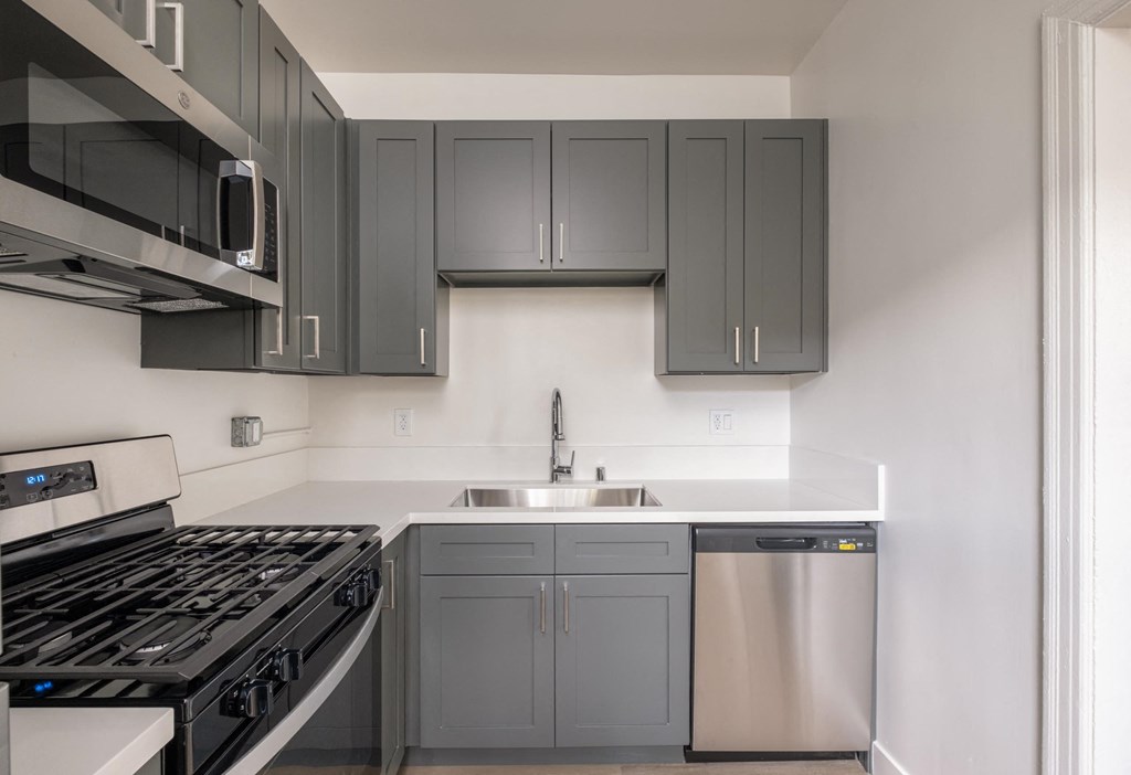 A kitchen with a stove, sink, and cabinets at Kenmore Park Apartments, Los Angeles, CA, 90004