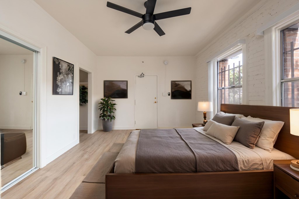 A bedroom with a large bed and a ceiling fan at Kenmore Park Apartments, Los Angeles, CA