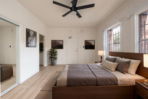 A bedroom with a large bed and a ceiling fan.