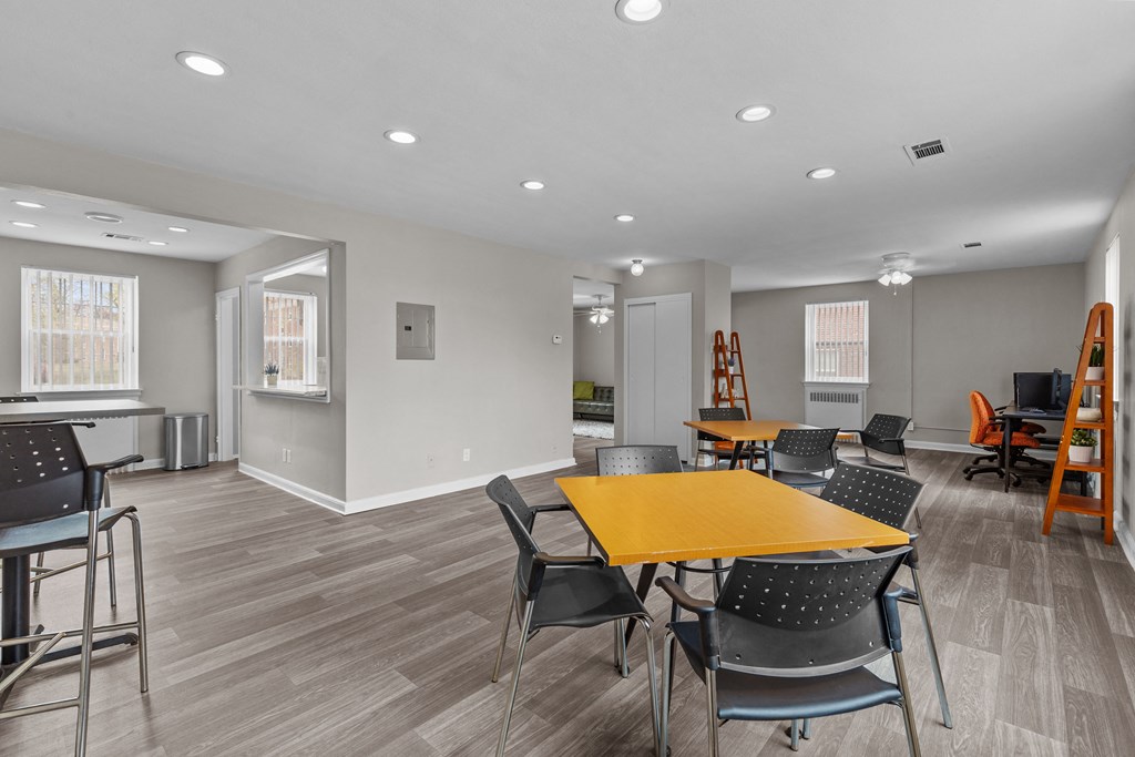 a community room with tables and chairs and a kitchen at Hampton Gardens, Missouri, 63139