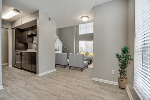 an open living room with a kitchen and a dining room with chairs and a table