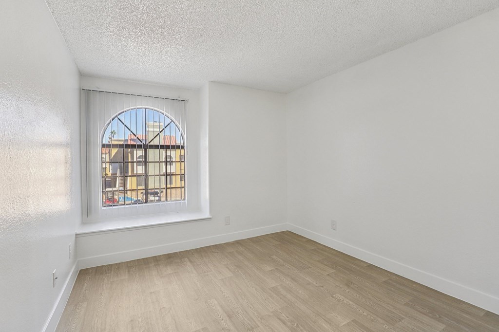 A room with a window and wooden flooring.