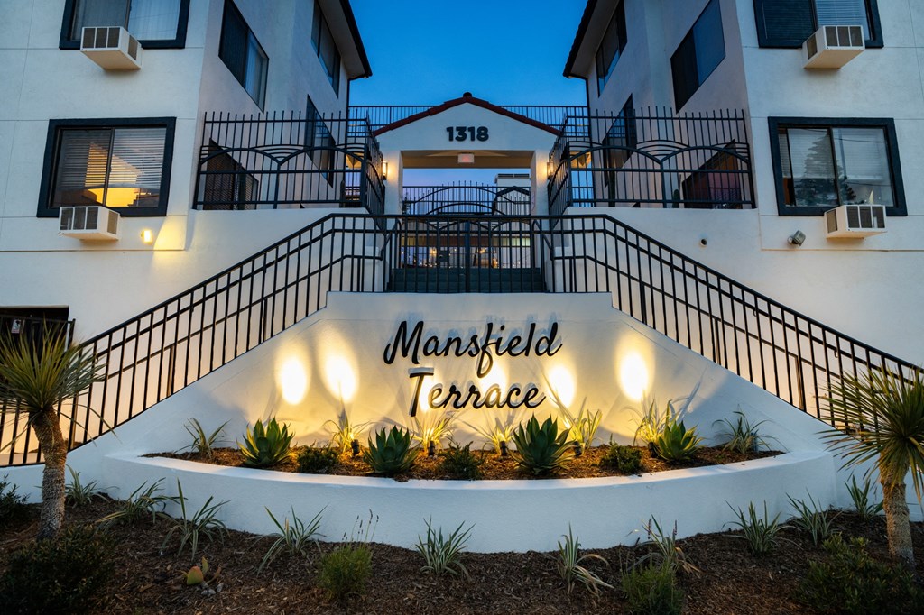 an image of the front entrance of the terrace apartment building at night