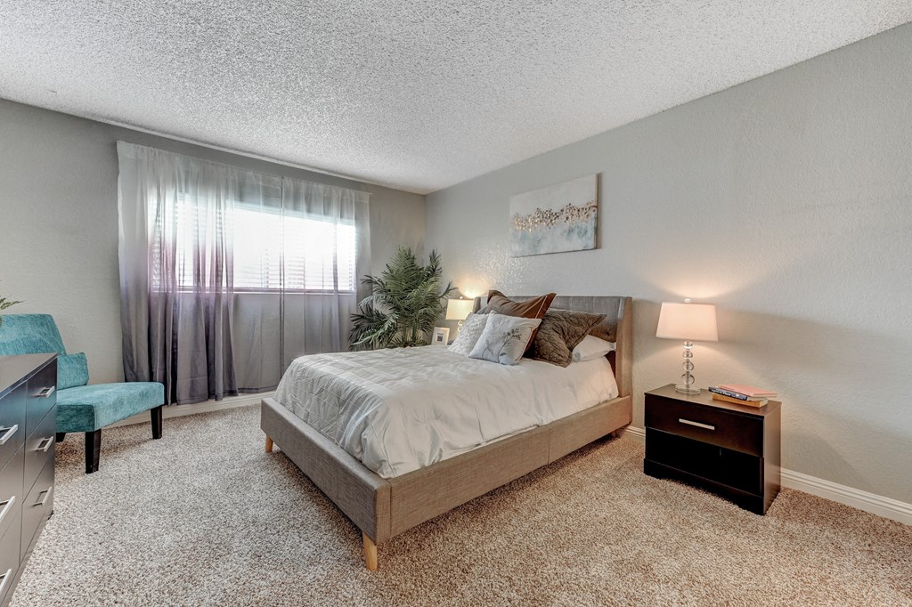 a bedroom with a bed and a dresser and a window a bedroom with a bed and a dresser and a window t Desert Bay Apartments, Laughlin, NV