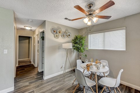 a dining room with a table and chairs and a ceiling fan