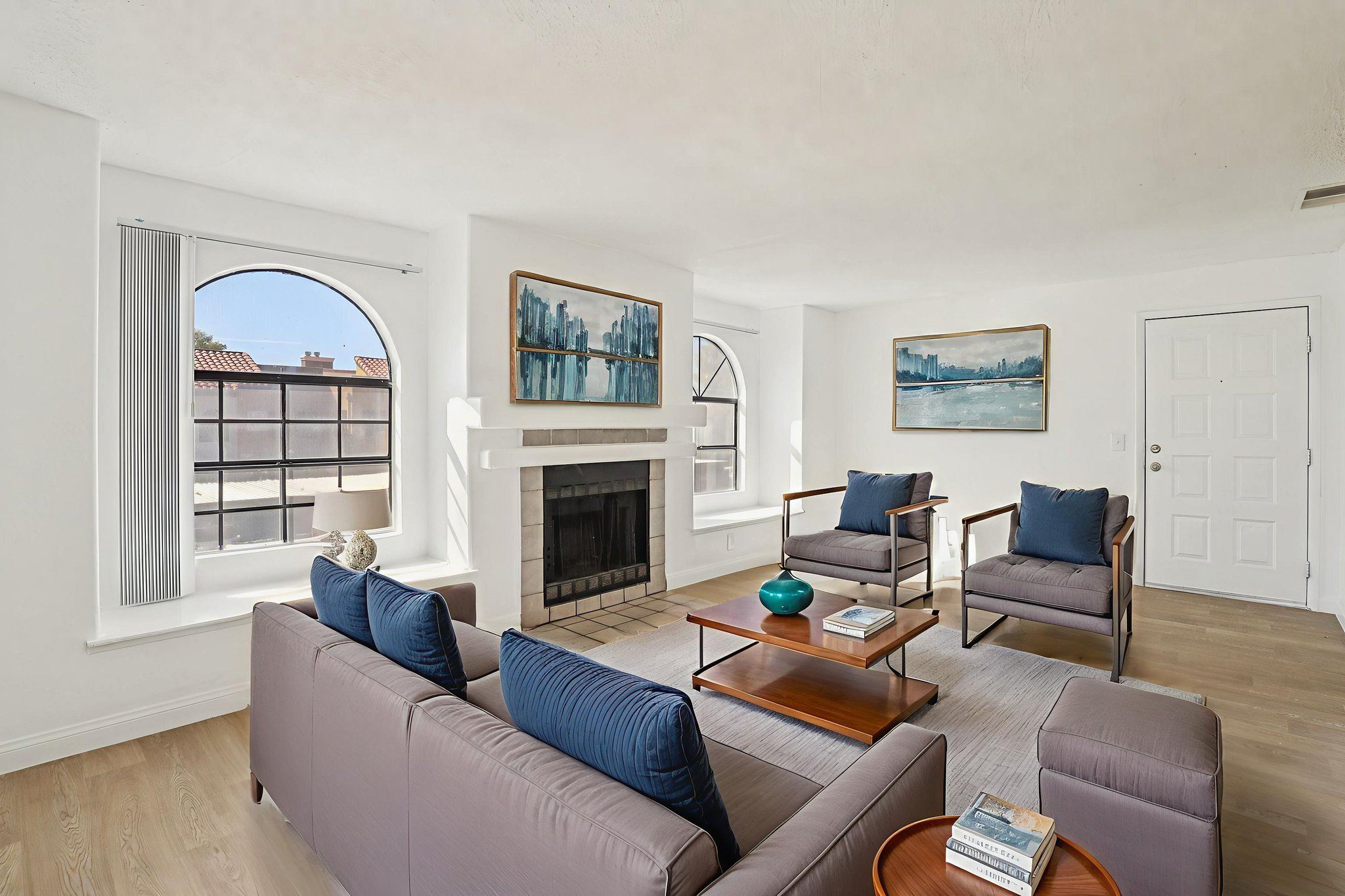 A living room with a fireplace and a painting on the wall.