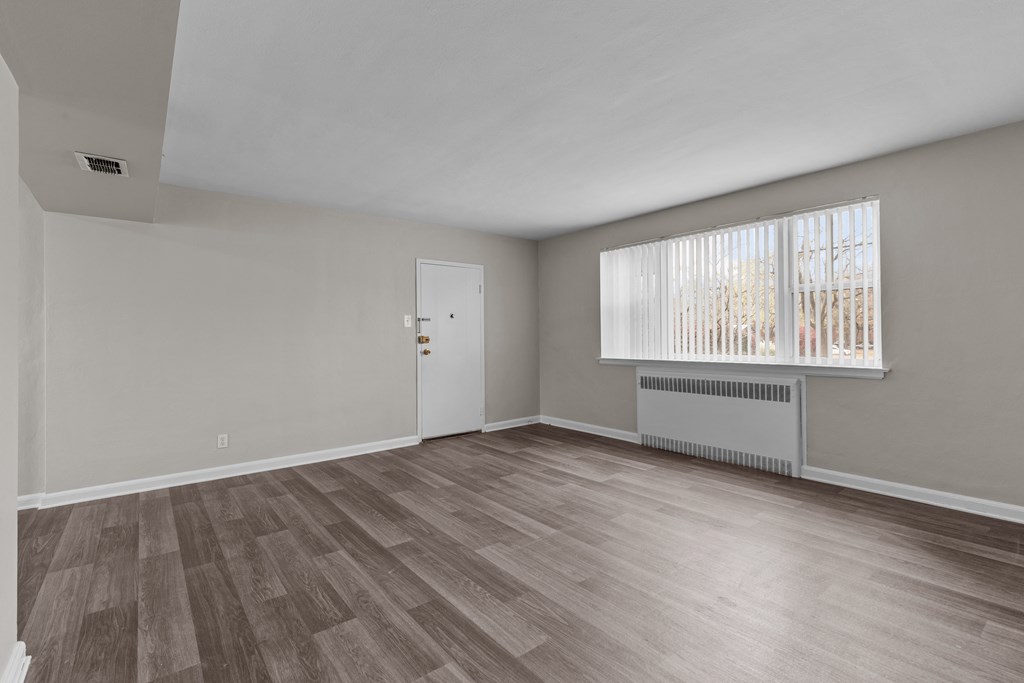the living room of an empty house with wood flooring and a window at Hampton Gardens, Missouri, 63139
