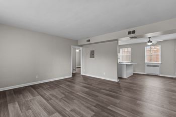 the living room and dining room of an empty house with wood flooring