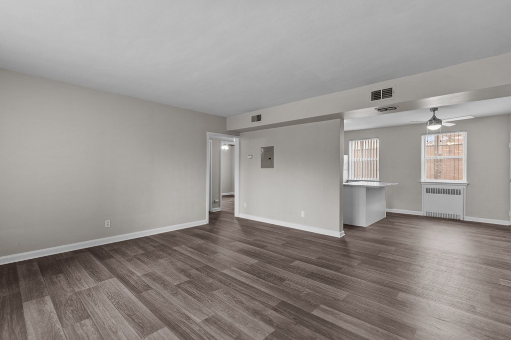 Living room and dining room of an empty house with wood flooring at Hampton Gardens, Missouri, 63139