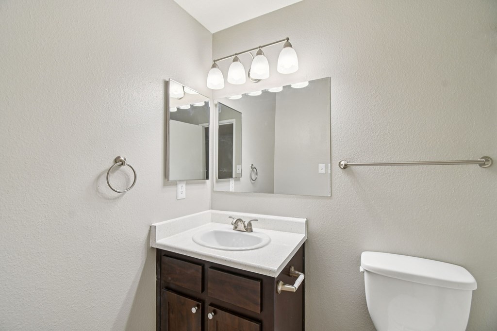 A bathroom with a sink, mirror, and toilet.