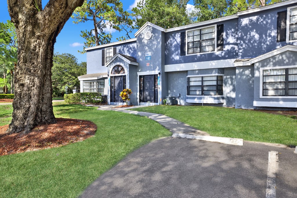 A blue house with a tree in front.