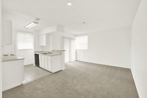 A kitchen area with a white counter and a trash bin.