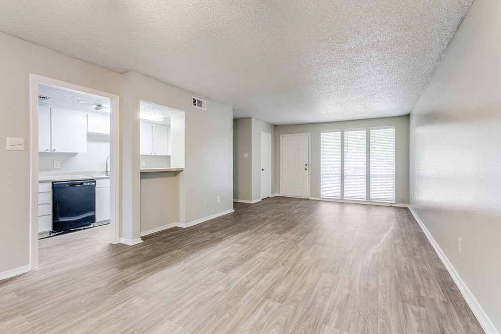 an empty living room and kitchen with a hard wood floor at Falls on Clearwood Apartments, Richardson, TX, Texas