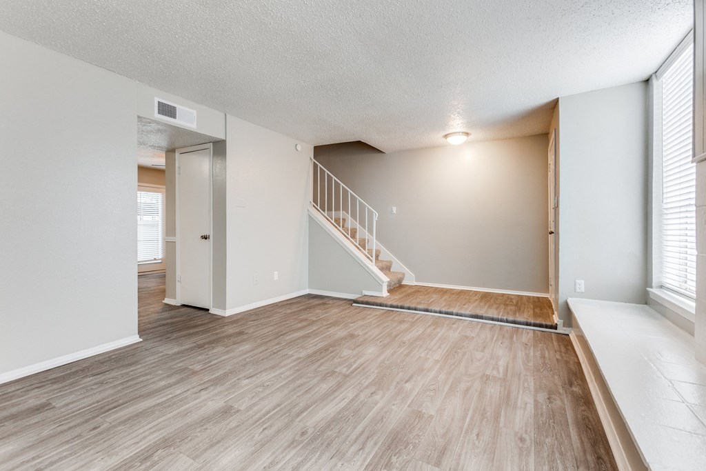 the spacious living room and dining room of an apartment at Falls on Clearwood Apartments, Richardson, TX, Texas
