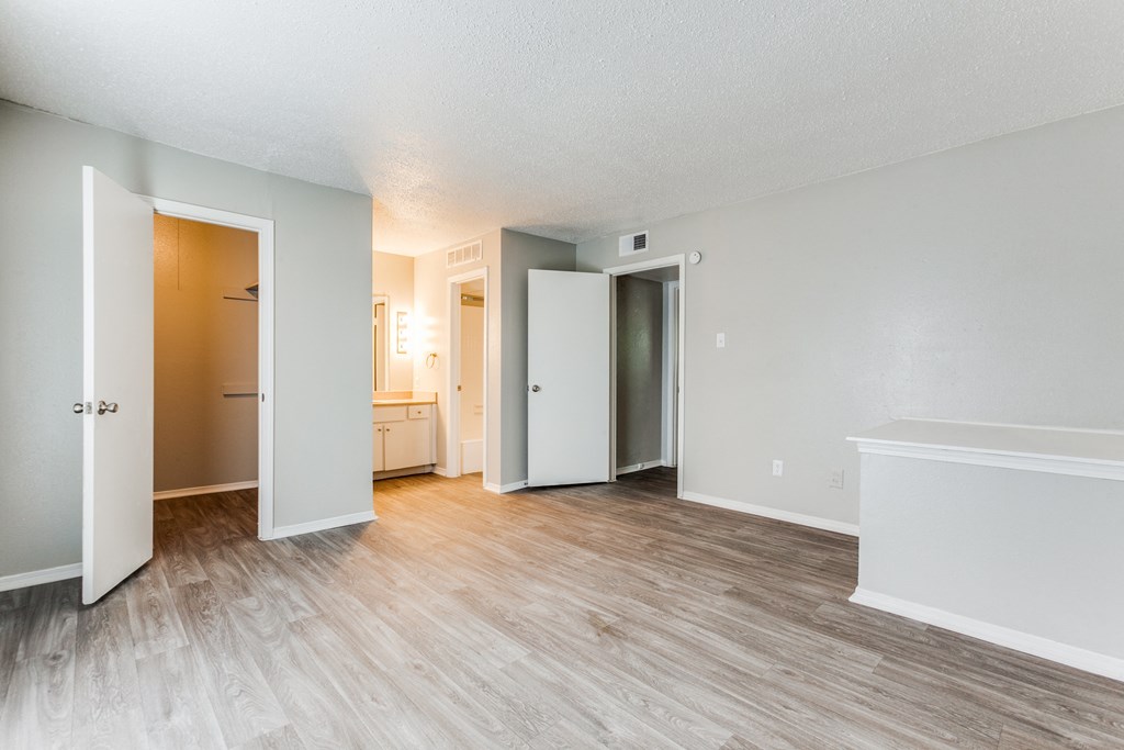 an empty living room with wood flooring and white walls at Falls on Clearwood Apartments, Richardson, TX, Texas
