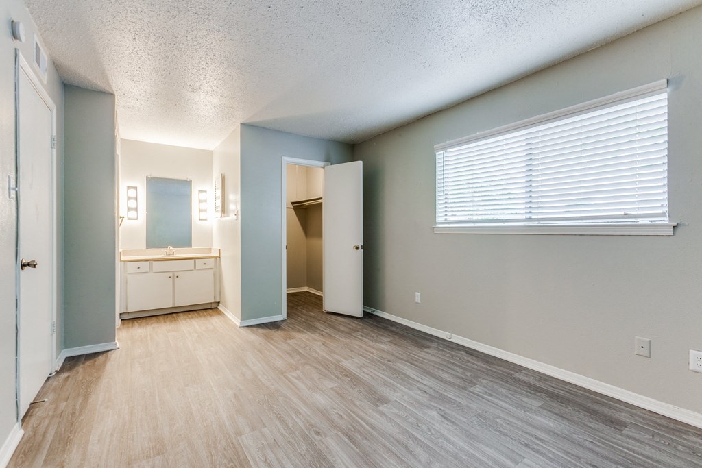an empty living room with a bathroom and a window at Falls on Clearwood Apartments, Richardson, TX, Texas