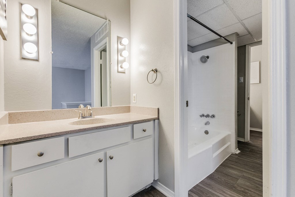 a bathroom with a sink and a shower and a mirror at Falls on Clearwood Apartments, Richardson, TX, Texas