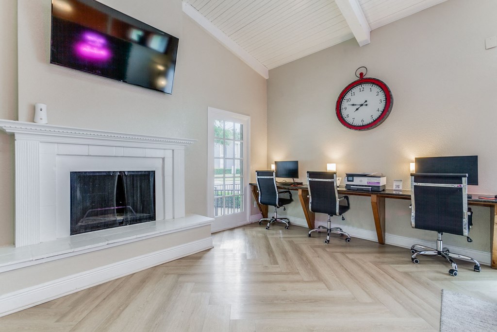 a home office with a fireplace and a clock on the wall at Falls on Clearwood Apartments, Richardson, TX, Texas