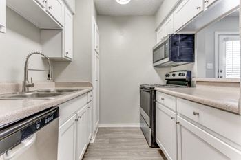 a kitchen with white cabinets and a sink and a microwave