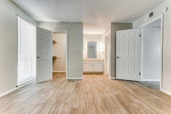 an empty living room with a door open to a bathroom