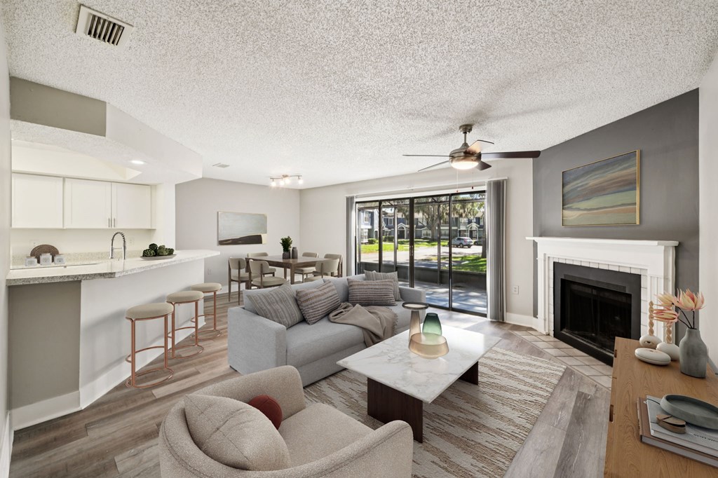 A living room with a grey couch and a fireplace.