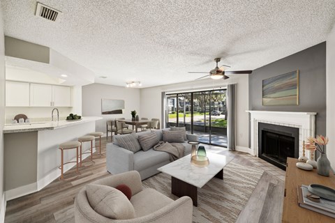 A living room with a grey couch and a fireplace.