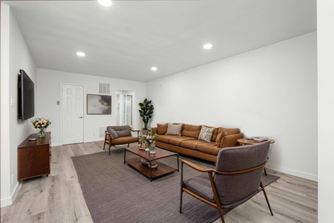 A living room with a brown couch, a chair, and a coffee table.