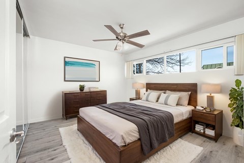 A bedroom with a large bed and a ceiling fan.