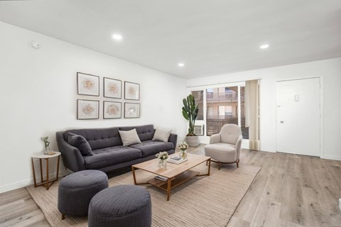 A living room with a grey couch, a coffee table, and a chair.