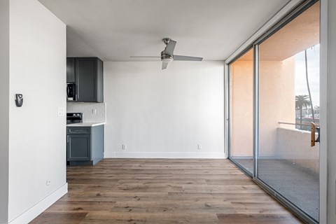 A modern kitchen with a wooden floor and a ceiling fan.at Menlo Terrace Apartments, Los Angeles, CA, 90006