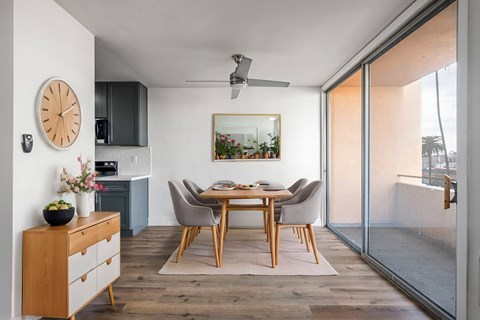 A modern dining room with a wooden table and chairs.