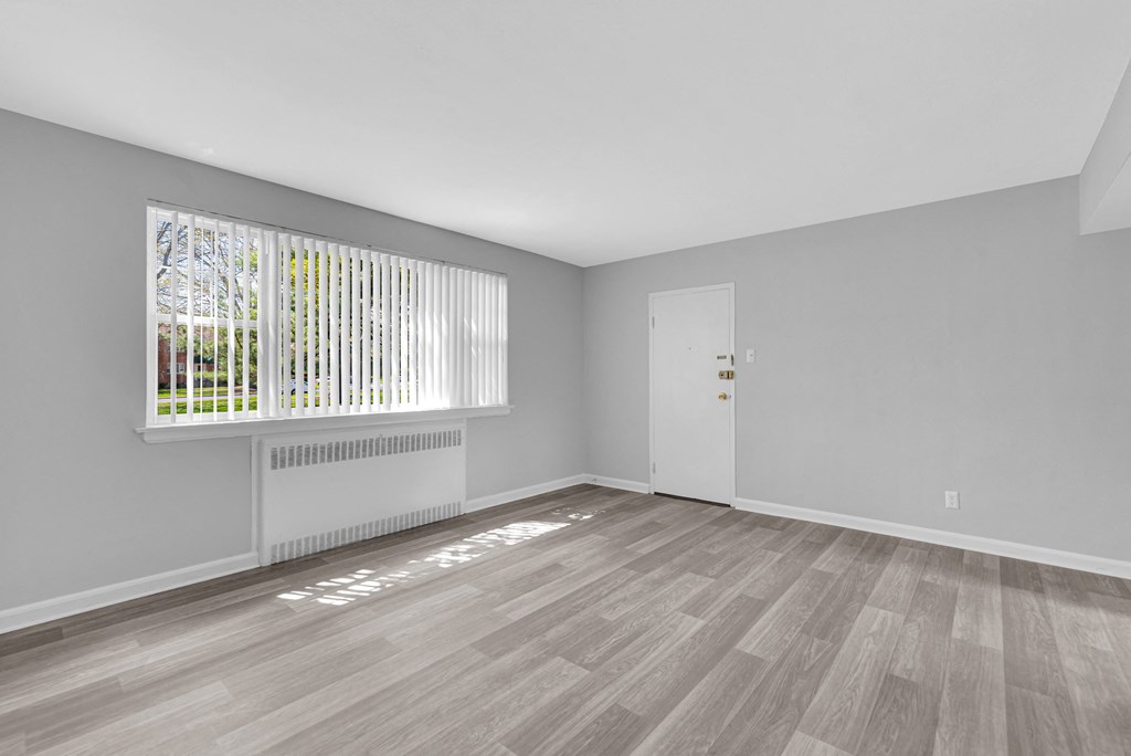 a bedroom with hardwood floors and grey walls at Hampton Gardens, Saint Louis, MO, 63139