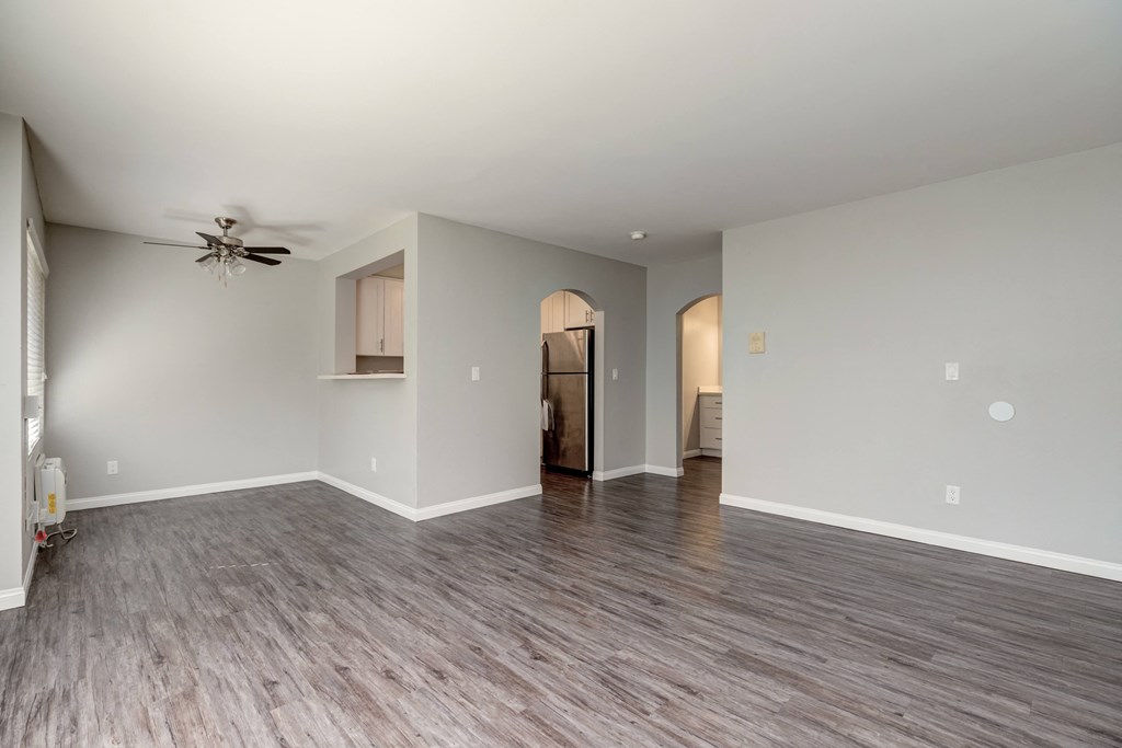 a living room with a ceiling fan and a hard wood floor