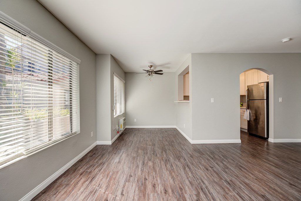 an empty living room with a large window and wood floors