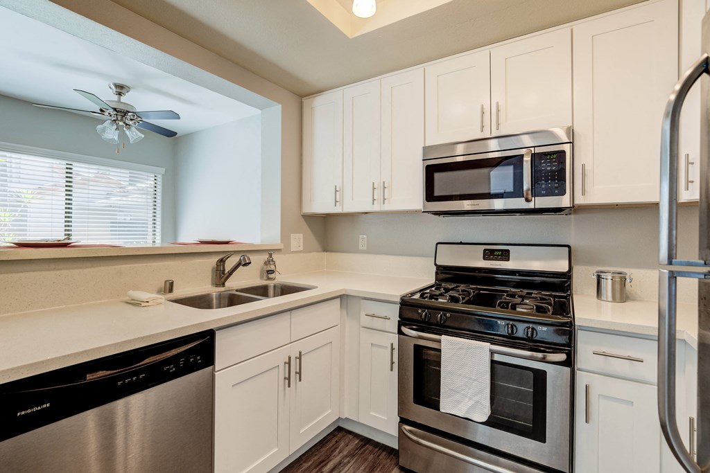 a kitchen with stainless steel appliances and white cabinets