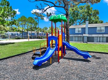 A playground with a blue slide and a green top.