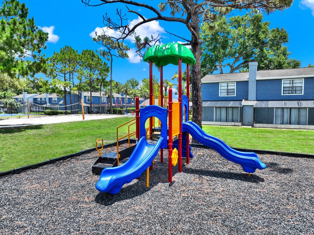 A playground with a blue slide and a green top.