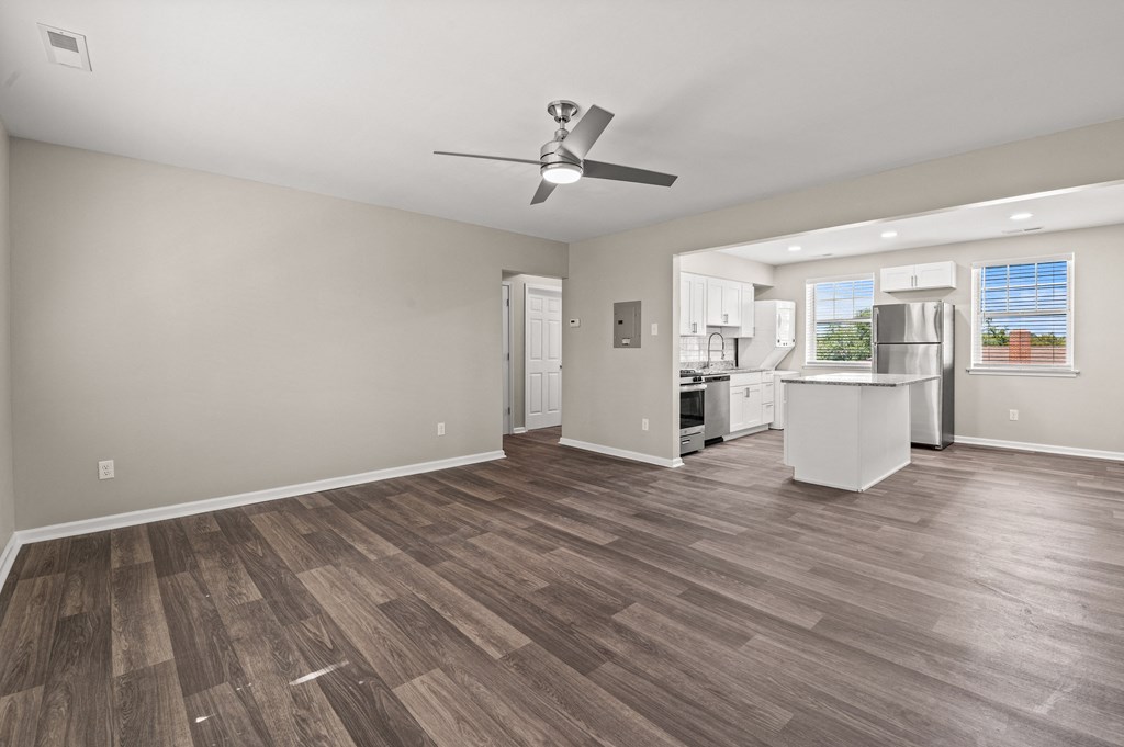 a living room with a ceiling fan and a kitchen in the background at Hampton Gardens, Saint Louis
