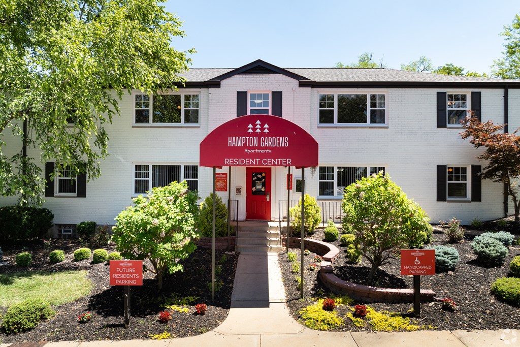 a white building with a red sign in front of it at Hampton Gardens, Missouri, 63139
