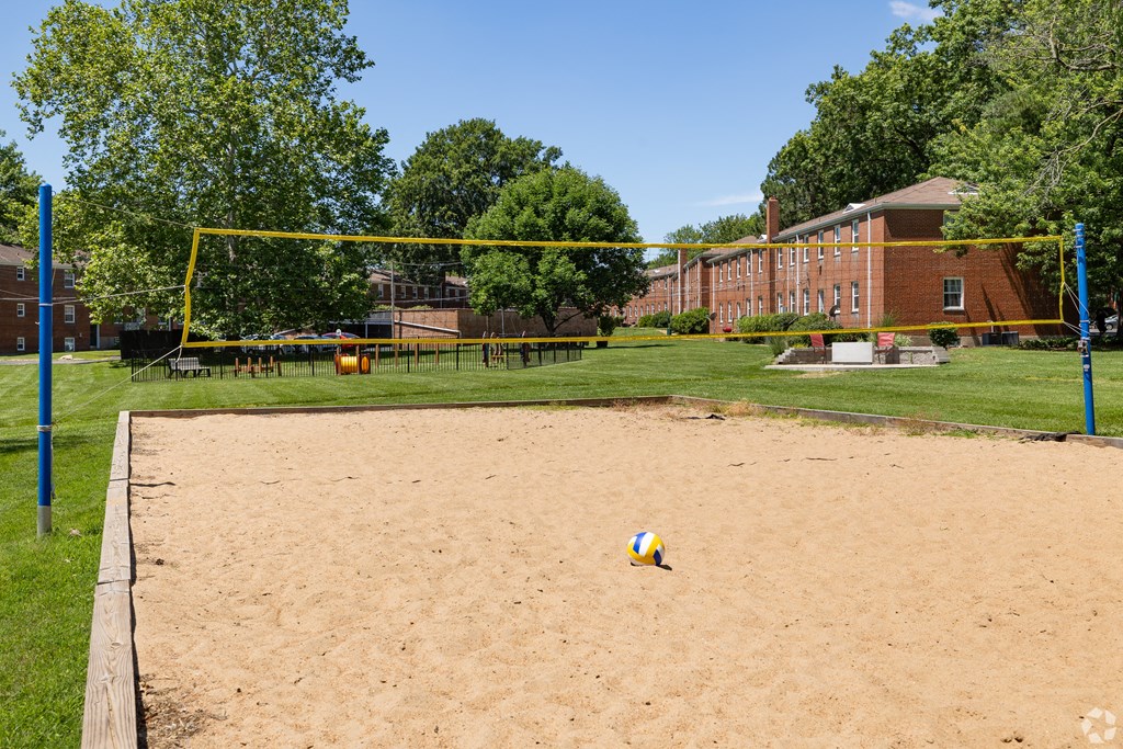 a volleyball court in front of a brick building with a volleyball at Hampton Gardens, Missouri, 63139
