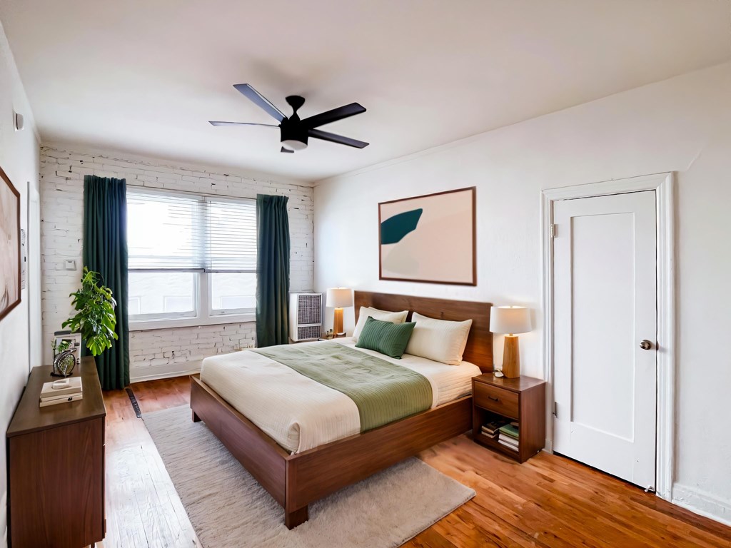 A bedroom with a bed, nightstand, and a ceiling fan at Kenmore Park Apartments, California, 90004