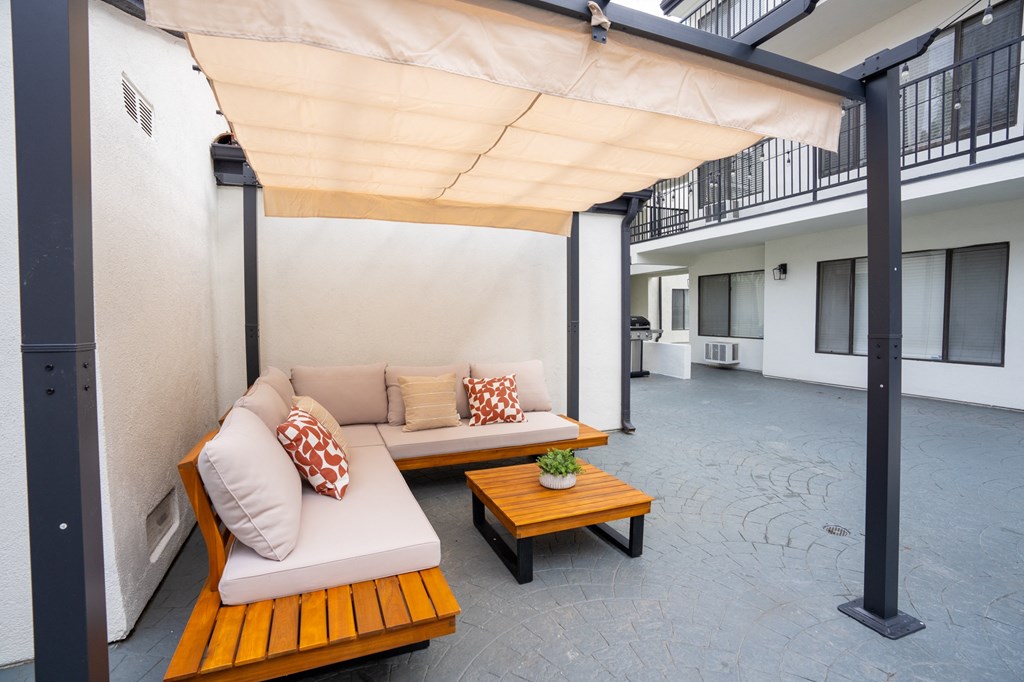 a patio with two couches and a wooden table