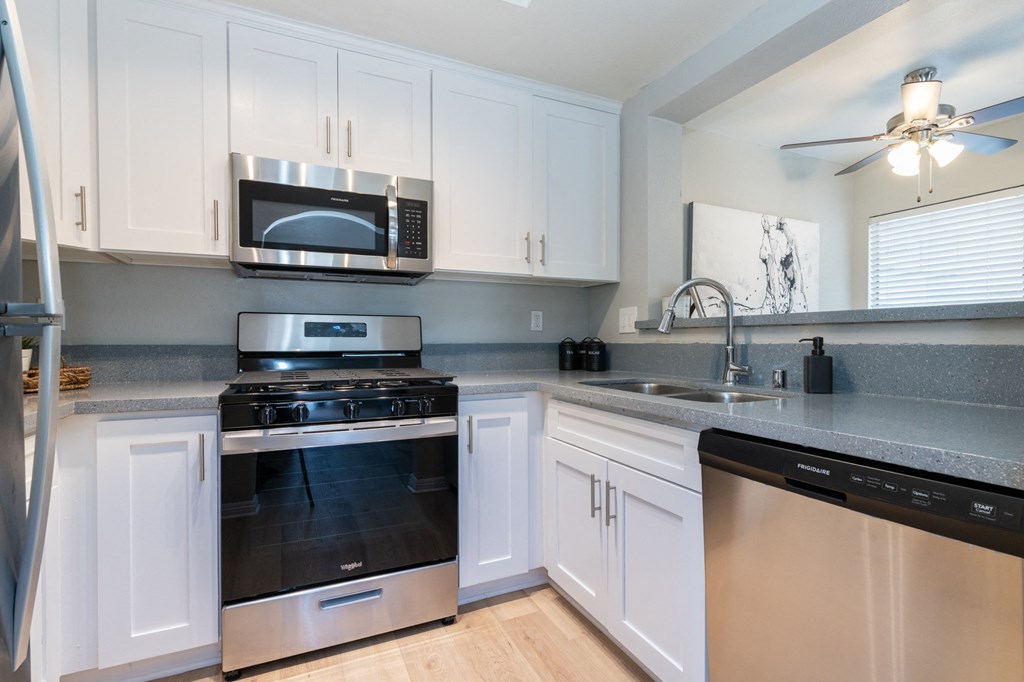 a kitchen with stainless steel appliances and white cabinets