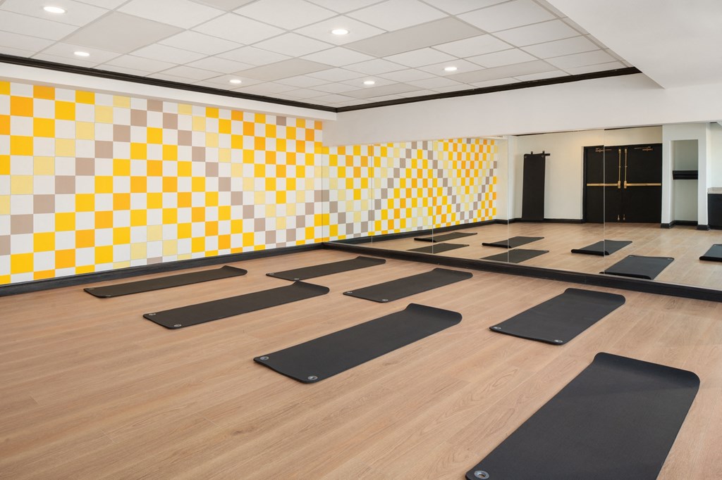 a yoga room with yellow and white checkered walls and yoga mats at Vision on Lombard, Baltimore