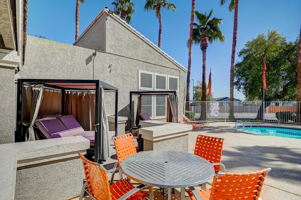 A patio with a table and chairs is set up outside a house.