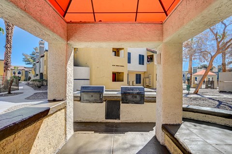 A patio with a table and chairs under an orange awning.