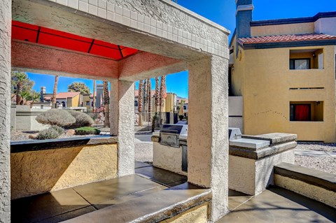 A patio with a red awning and a concrete bench.