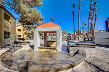 A small building with a red roof is surrounded by palm trees.