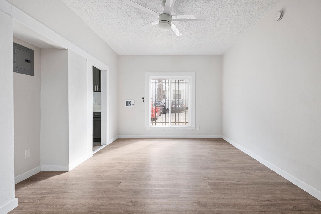 A spacious room with a ceiling fan and a window overlooking a cityscape. A spacious room with a ceiling fan and a window overlooking a cityscape at Hillstone Flats Apartments, California