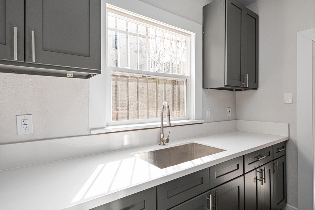 A kitchen with a white countertop and a window at Hillstone Flats Apartments, Los Angeles, California